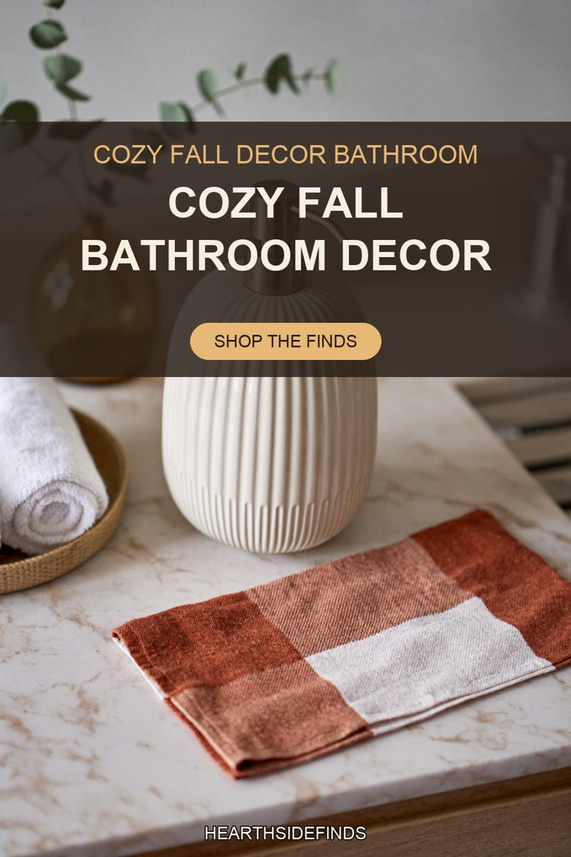 A fluted cream ceramic soap dispenser stands on a pale veined marble bathroom vanity, a folded rust and cream checked hand towel lying flat in front of it, rolled white towels in a round rattan tray cut off by the left edge, an amber glass vase of dried eucalyptus behind it, and blurred pale slats beyond the vanity edge at the right.