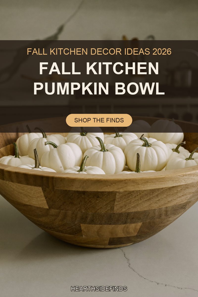 Wooden bowl heaped with white mini pumpkins on a pale stone counter, range and utensil crock behind.