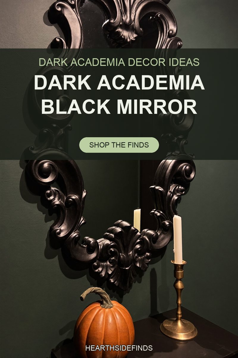 Ornate matte black scrolled mirror on a deep green wall above an orange pumpkin and a brass candlestick.