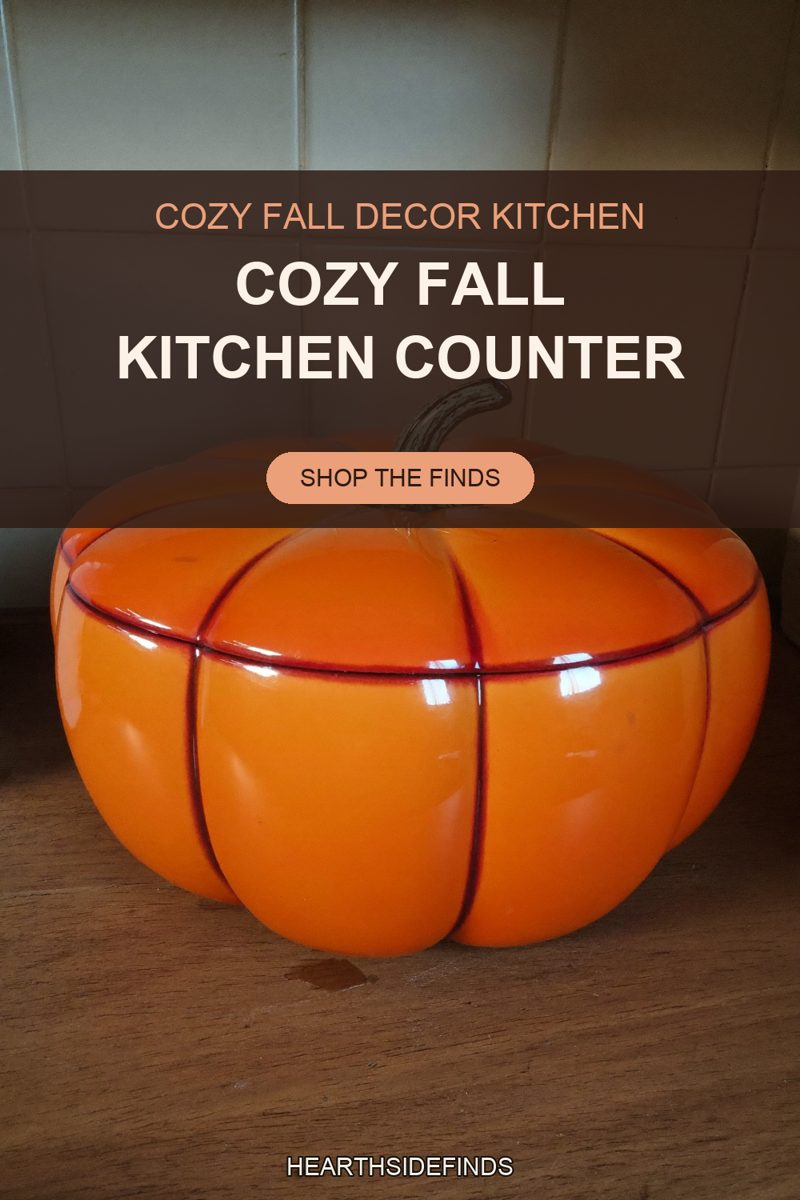 Glossy orange ceramic pumpkin serving bowl with a green stem lid on a wood counter by cream tile.