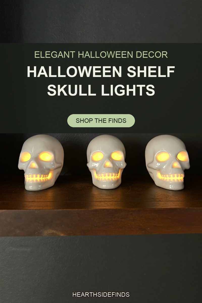 Three glossy white ceramic skulls on a dark wood shelf, warm light glowing in their eyes and teeth.